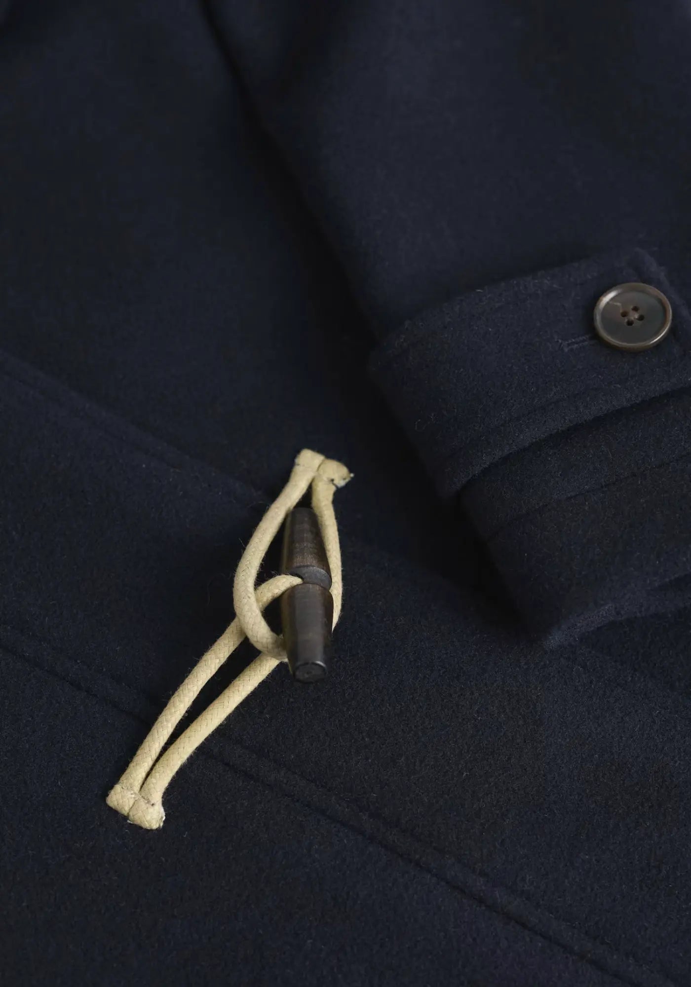 Mit dem Cardinham Duffle Mantel in Blau bleibst du warm und modisch. Recycelter Wollmix, Kapuze und Holzknöpfe machen ihn zum Must-have für die kalte Jahreszeit.