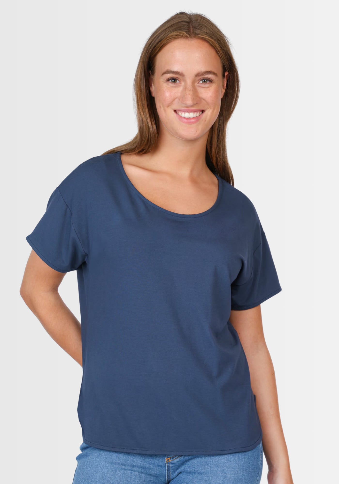 Frau lächelt in die Kamera und präsentiert das locker geschnittene T-Shirt „Betzi“ in Dunkelblau, das sich perfekt für jeden Tag eignet.