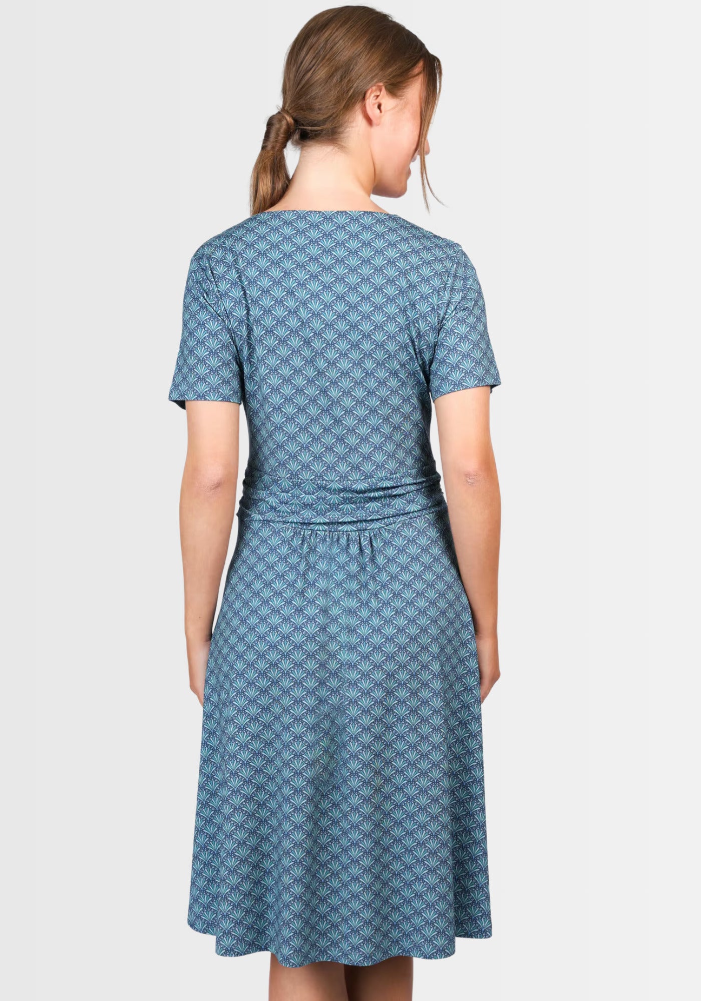 Rückansicht des taillierten Kleids „Malindamia“ in Dunkelblau, das die feminine Silhouette und den schwungvollen Rockteil betont. Gefertigt aus nachhaltiger Viskose für ein luftiges Tragegefühl.