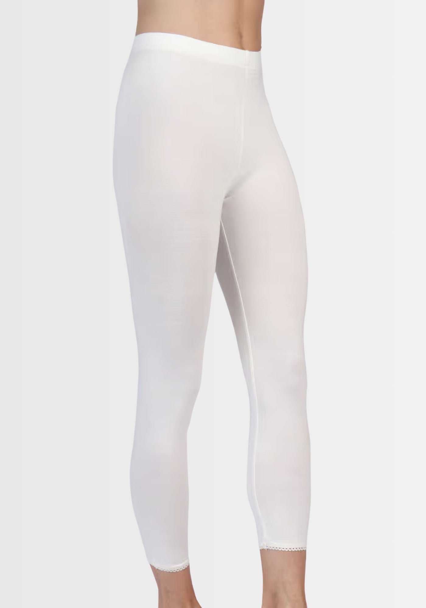Seitliche Ansicht der Leggings „Antje“ in Elfenbeinweiß, die ihre figurbetonte Silhouette und den weichen Stoff besonders hervorhebt.
