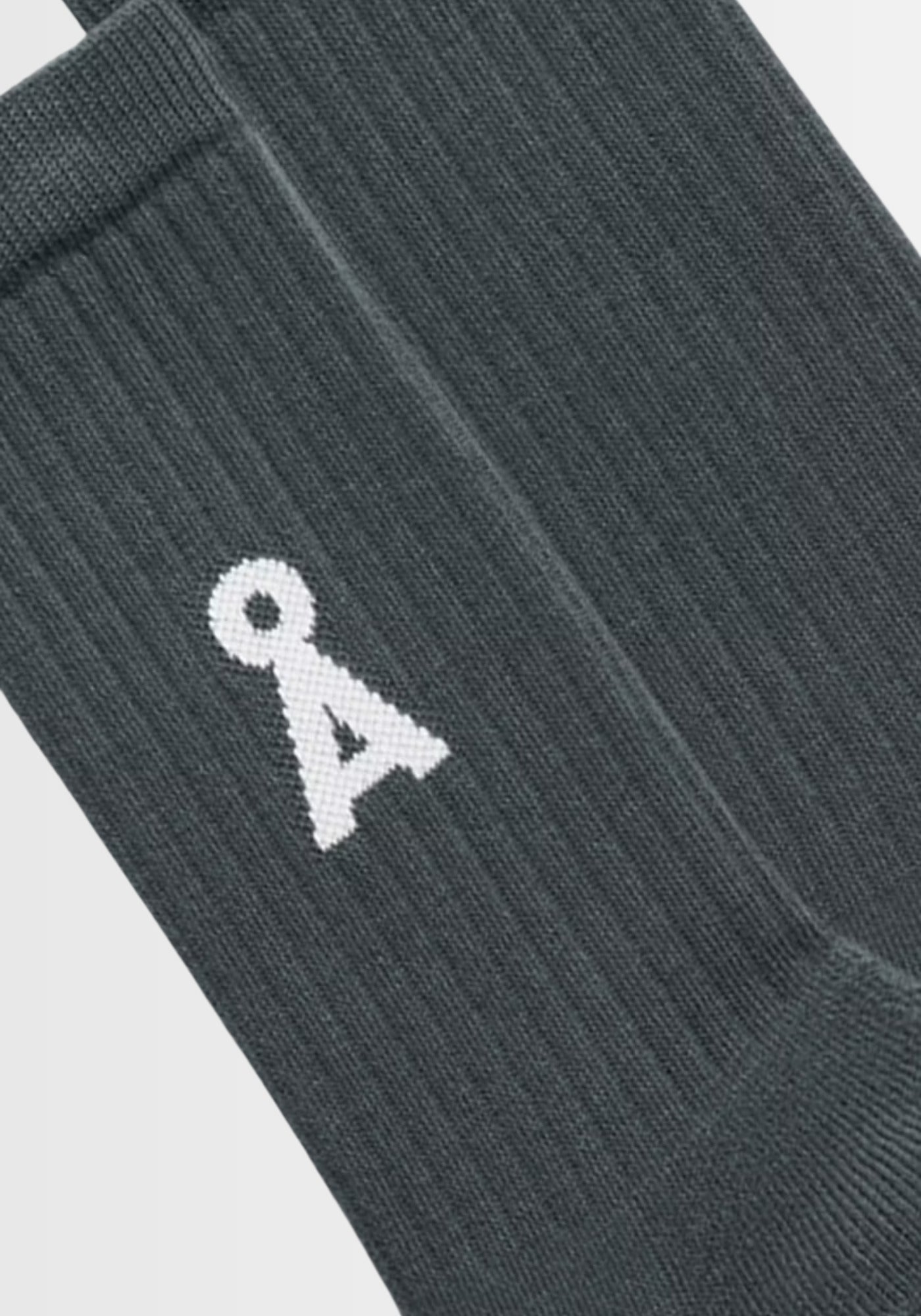 Dieses Bild zeigt die SAAMUS BOLD Socks in „space steel“, einem metallisch-grauen Farbton, gefertigt aus 78% Bio-Baumwolle, 20% recyceltem Polyamid und 2% Elasthan. Das markante A‑Logo betont den nachhaltigen Look – produziert in Braga, Portugal, GOTS‑zertifiziert und PETA‑approved vegan.