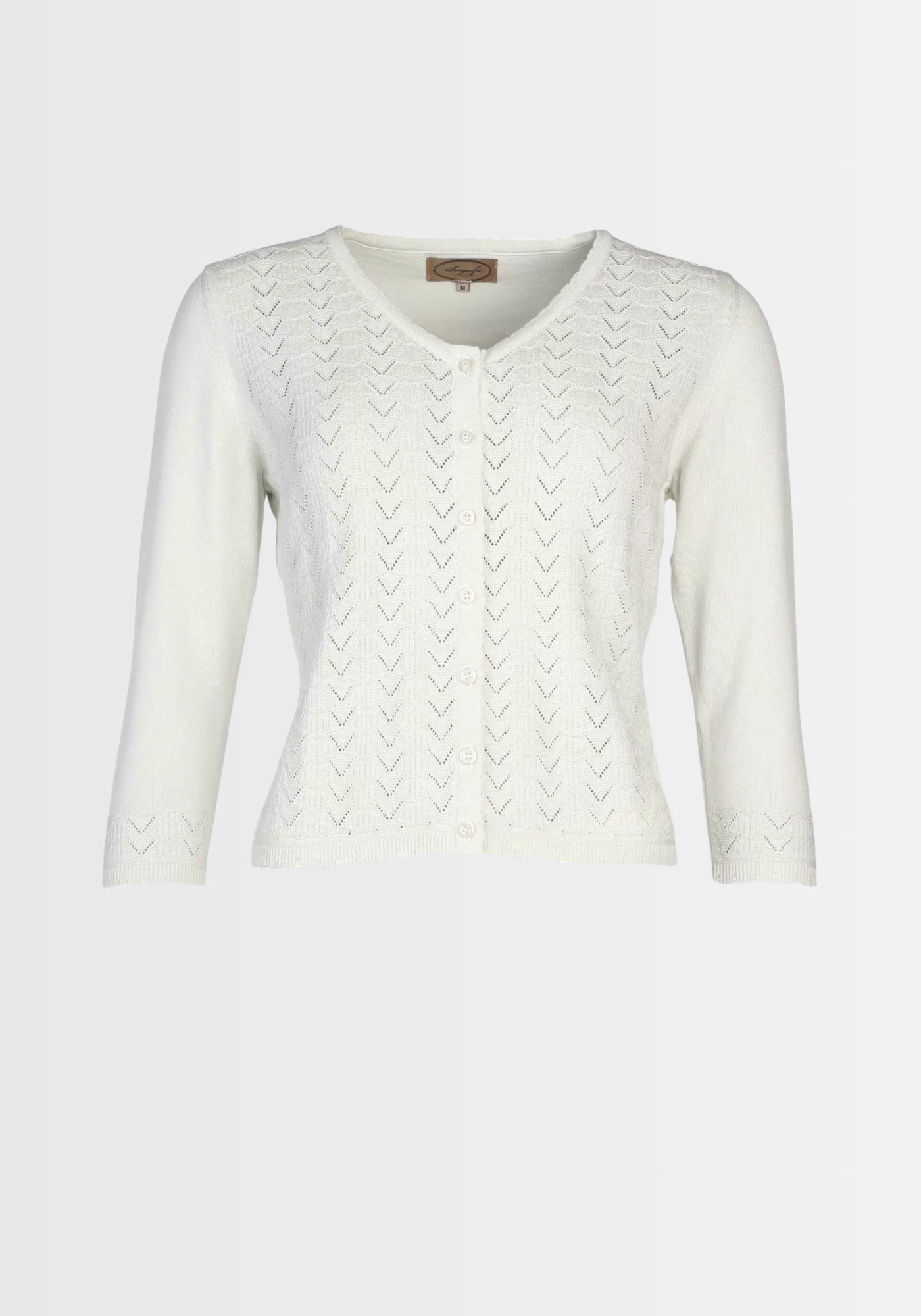 Model präsentiert die „Liselotte“ Strickjacke in Weiß aus 100% Bio-Baumwolle in einem eleganten Freizeitlook. Das feine Ajourmuster und der klassische Schnitt machen diesen Cardigan zur idealen Ergänzung zu Kleidern und Röcken.