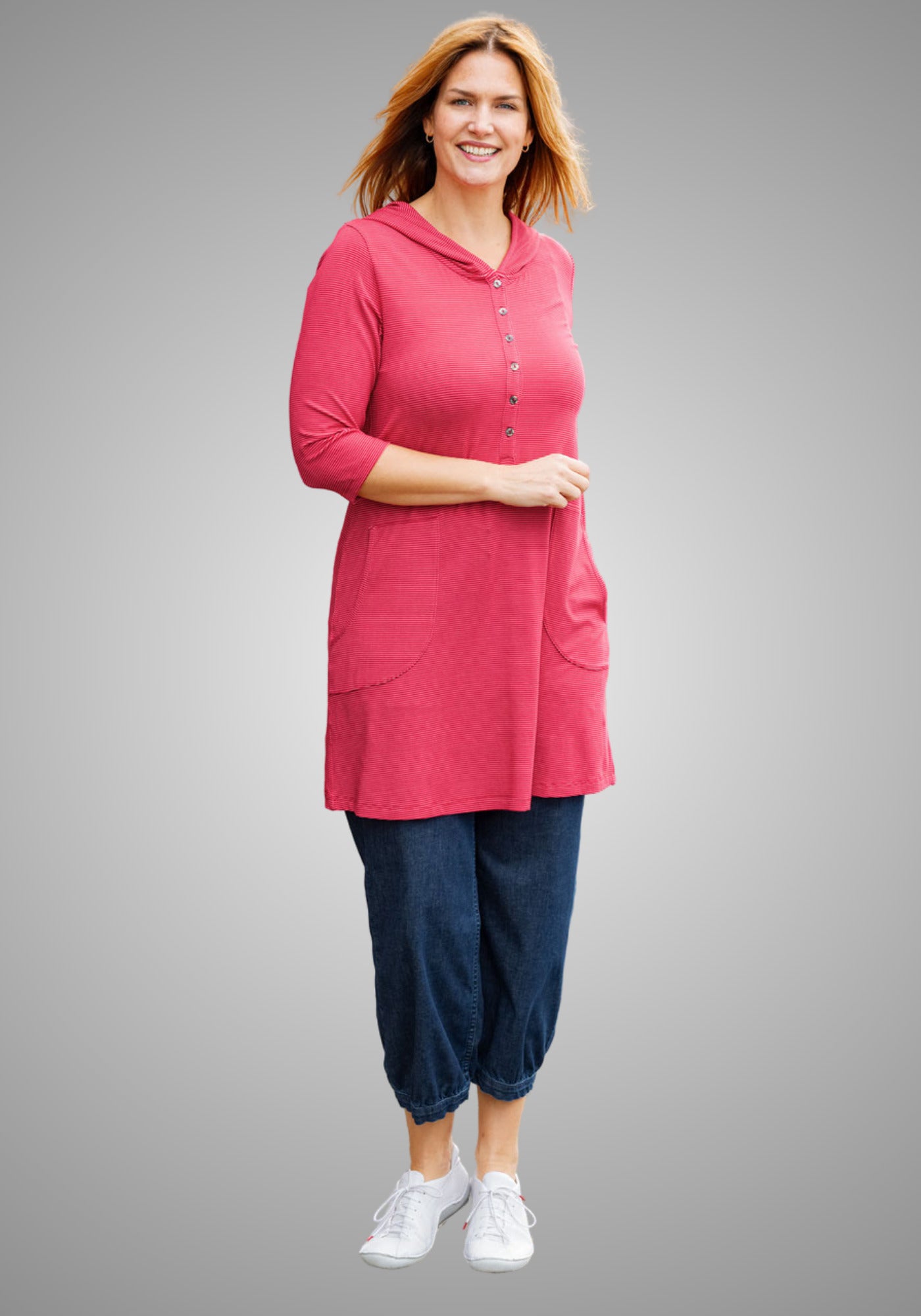 Frau trägt ein bequemes Outfit mit dunkelblauer Denim-Pumphose von Heidekönigin und rotem Oberteil, perfekt für Alltag und Freizeit.

