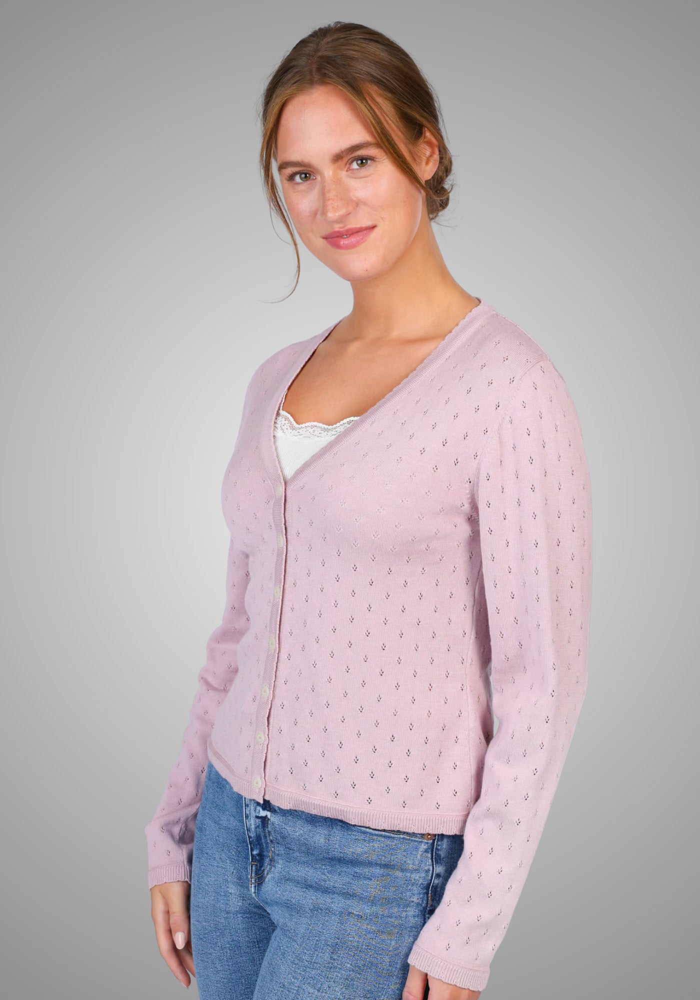 Rückansicht der eleganten, rosa Strickjacke „Amily“ von Sorgenfri Sylt. Der klassische Schnitt mit V-Ausschnitt und dezentem Ajourmuster rundet den femininen Look ab.