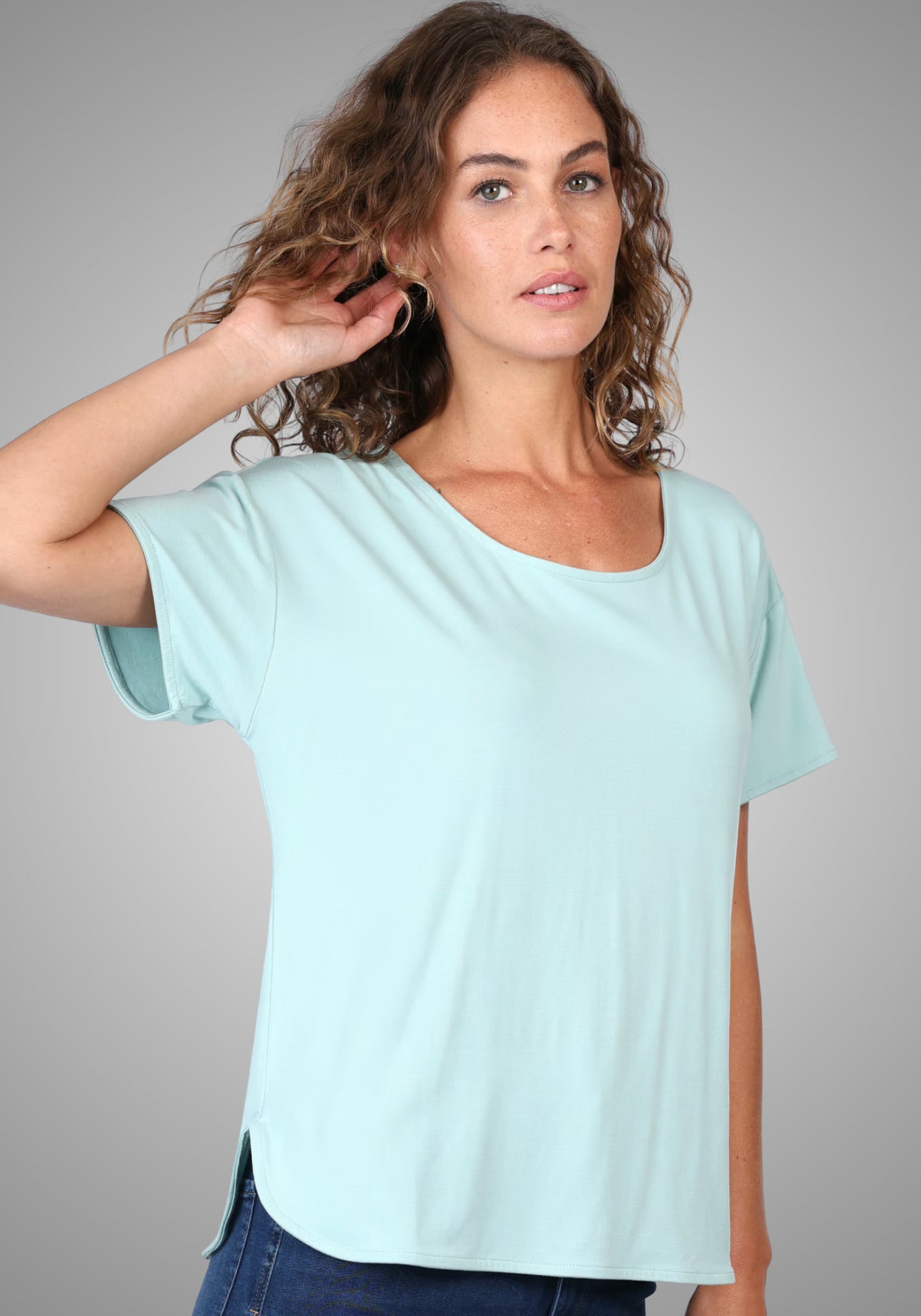 Model präsentiert das T-Shirt "Betzi" in einem frischen Turquoise-Ton, gefertigt aus 95% LENZING™ ECOVERO™ Viskose und 5% Elasthan. Der schlichte Rundhalsausschnitt und der locker geschnittene Stil machen es zum idealen Basic für jeden Tag.

